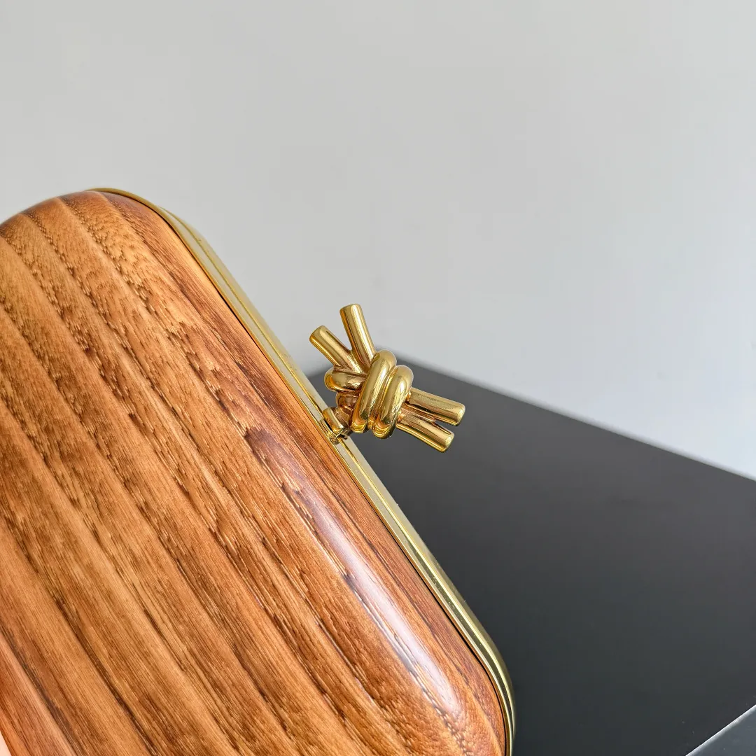 Batch 2720 BOTTEGA VENETA2025 new kont evening bag When the natural texture of wood meets the brass edge, the BV evening bag becomes a work of art in the fashion world. Every wood grain is a mark of time, delicate and unique. The brass metal buckle is embellished like stars, and opening it is full of ritual. It is the focus of the dinner party, and can easily store your exquisite small things. The warmth of wood and the cold and cool collision of metal tell the niche light luxury style in every gesture, allowing you to shine with a unique attitude in every feast. Style number: 804292 (717622) Color: maroon Size: 20.5*6*12.5cm